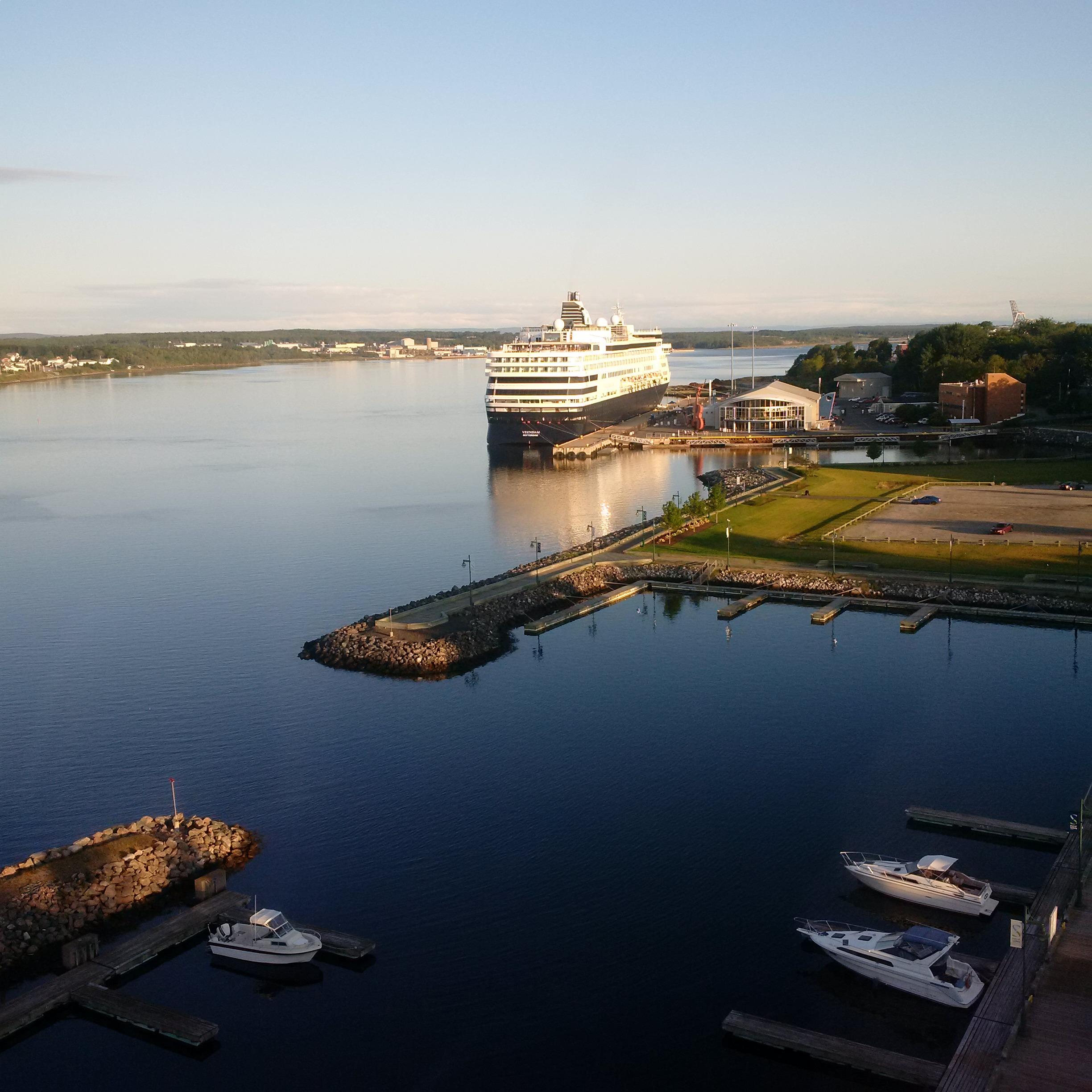 A large ship and smaller boats docked at port representing economic opportunities for Cape Breton